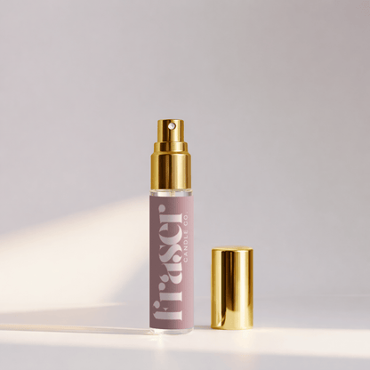 Perfume bottle with gold cap and label on a light gray background